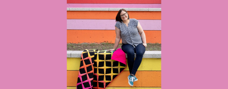 laura hopper in front of a striped wall with a colorful quilt